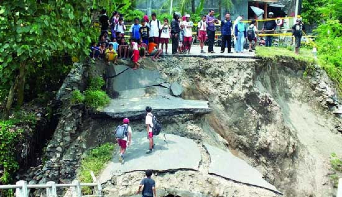 AMBRUK: Sebagian masyarakat melihat jembatan antar kabupaten di Desa Ngadi, Kecamatan Mojo, Kabupaten Kediri, Jawa Timur yang ambruk, Selasa (28/2). Ambruknya jembatan yang menghubungkan jalur alternati Kediri dan Tulungagung ini karena arus sungai di bawahnya yang terlampau deras. - JPNN.com
