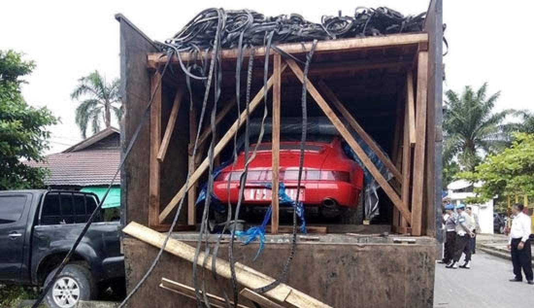 MOBIL MEWAH: Sebuah truk fuso bermuatan dua unit mobil sport Porsche Carrera 4 disita di Mapolda Kalbar, Rabu (1/3). - JPNN.com