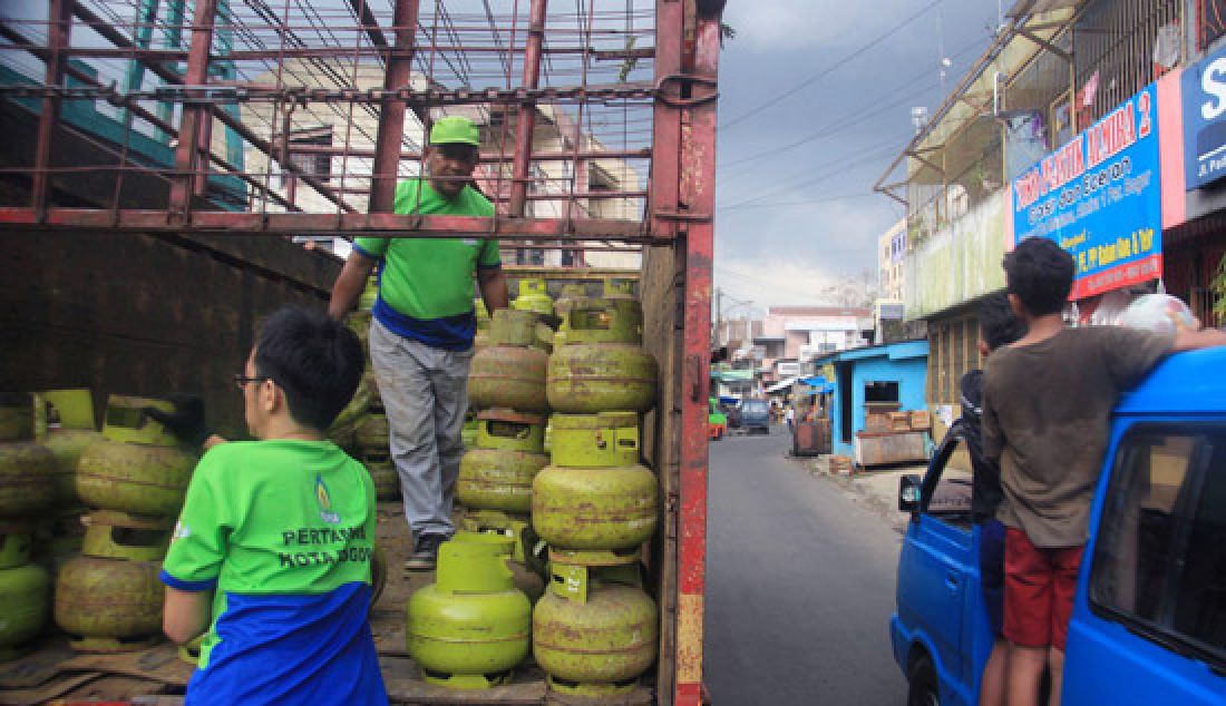 Pekerja sedang melakukan bongkar muat di depot Gas di pasar Lawang Saketeng, Bogor. Jumat (3/3). Warga Bogor terlebih yang bermukim di perumahan dibuat kelimpungan mencari gas elpiji ukuran tiga kilogram selama sepekan ini. Gas elpiji ukuran tiga kilogram sendiri telah berganti menjadi gas elpiji ukuran 5,5 kilogram (Pink). - JPNN.com