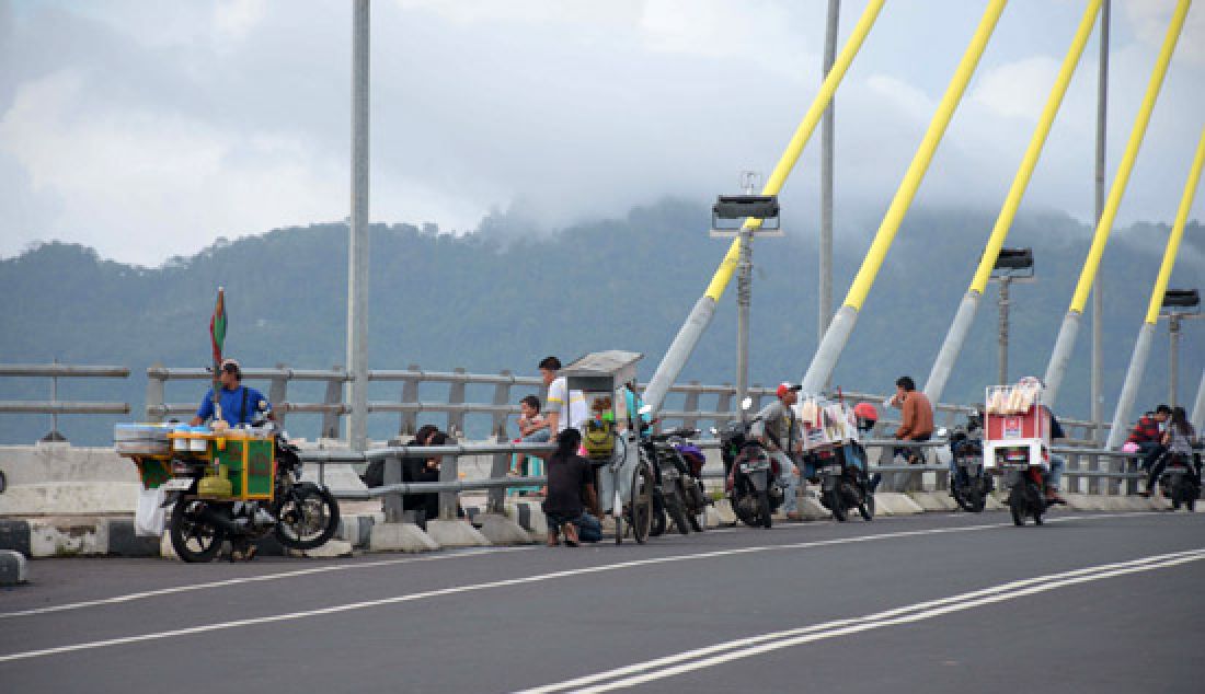 MENJAMUR: Setiap sore hari sampai malam hari para pedagang asongan menggunakan bahu jalan Jembatan Soekarno sebagai tempat jualan. Minggu (5/3). Jika tidak ada tindakan tegas dari pemerintah, maka para pedagang akan terus bertambah. - JPNN.com