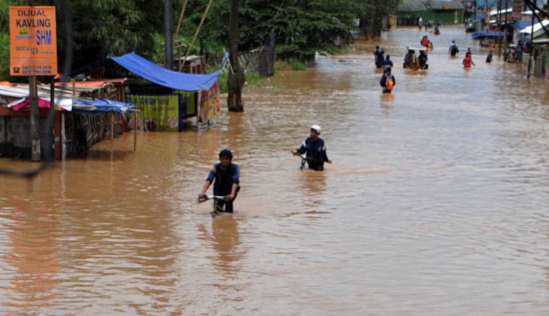 MAKIN MEULAS: Warga menerobos banjir di Jalan Dayeuhkolot, Kabupaten Bandung, Rabu (8/2). Banjir musiman yang disebabkan meluapnya Sungai Citarum itu semakin meluas. - JPNN.com