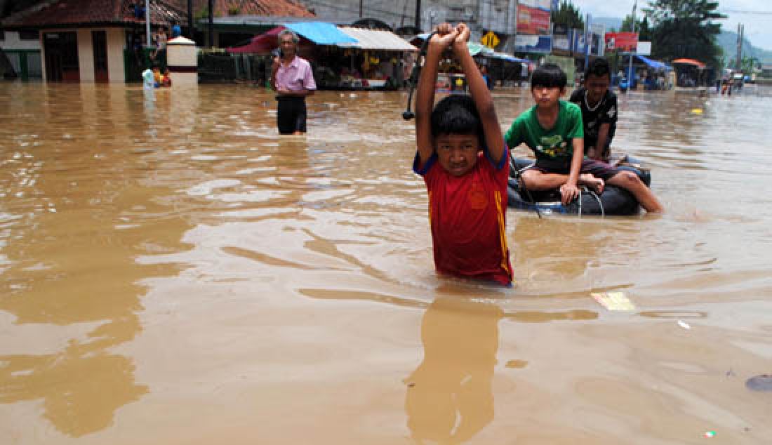 MAKIN MEULAS: Warga menerobos banjir di Jalan Dayeuhkolot, Kabupaten Bandung, Rabu (8/2). Banjir musiman yang disebabkan meluapnya Sungai Citarum itu semakin meluas. - JPNN.com