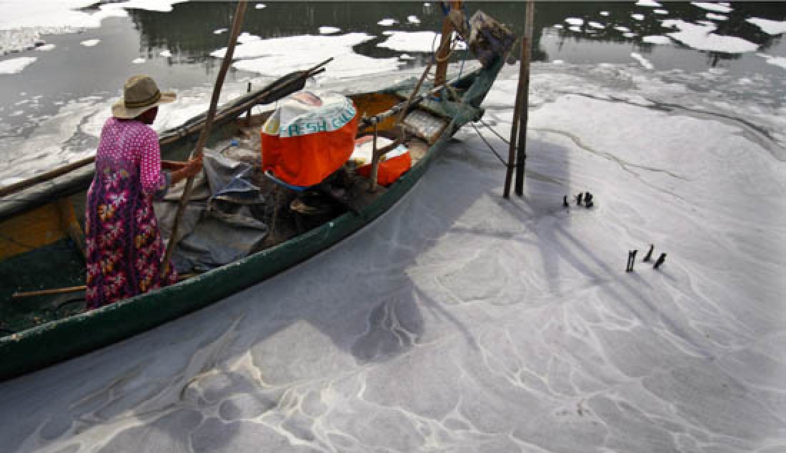 Limbah busa mengelilingi perahu-perahu nelayan yang ada di kawasan kampung nelayan Tambak Wedi, kota Surabaya, Rabu (8/3). Limbah busa sering kali tampak mengalir ke laut di kawasan tersebut. - JPNN.com