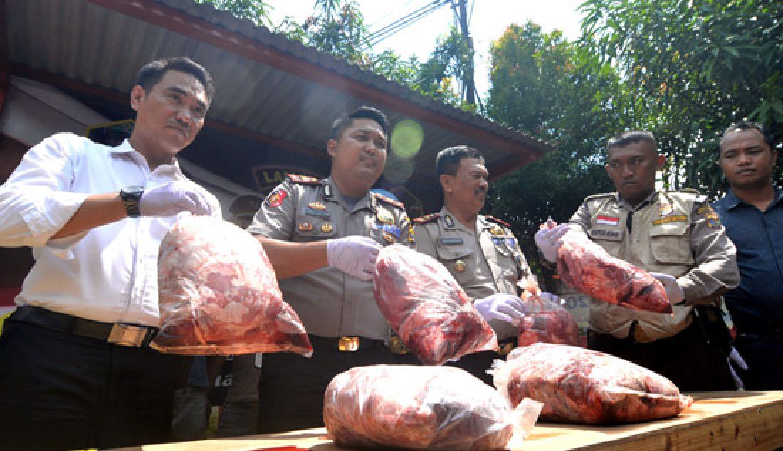 Anggota Kepolisian Sektor Kawasan Pelabuhan (KSKP) Panjang membongkar karung berisi daging celeng, Kamis (9/3). Sebanyak 3 ton daging tanpa dokumen asal Jambi ini rencananya akan dibawa ke Pelabuhan Tanjung Priok melalui jalur tol laut. - JPNN.com