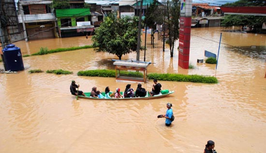 MAKIN MELUAS: Warga menerobos banjir di Jalan Dayeuhkolot, Kabupaten Bandung, Rabu (8/2). Banjir musiman yang disebabkan meluapnya Sungai Citarum itu semakin meluas. - JPNN.com