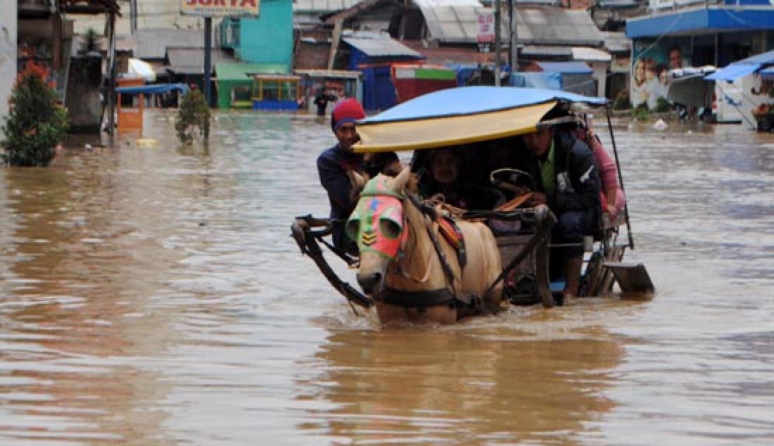 MAKIN MELUAS: Warga menerobos banjir di Jalan Dayeuhkolot, Kabupaten Bandung, Rabu (8/2). Banjir musiman yang disebabkan meluapnya Sungai Citarum itu semakin meluas. - JPNN.com