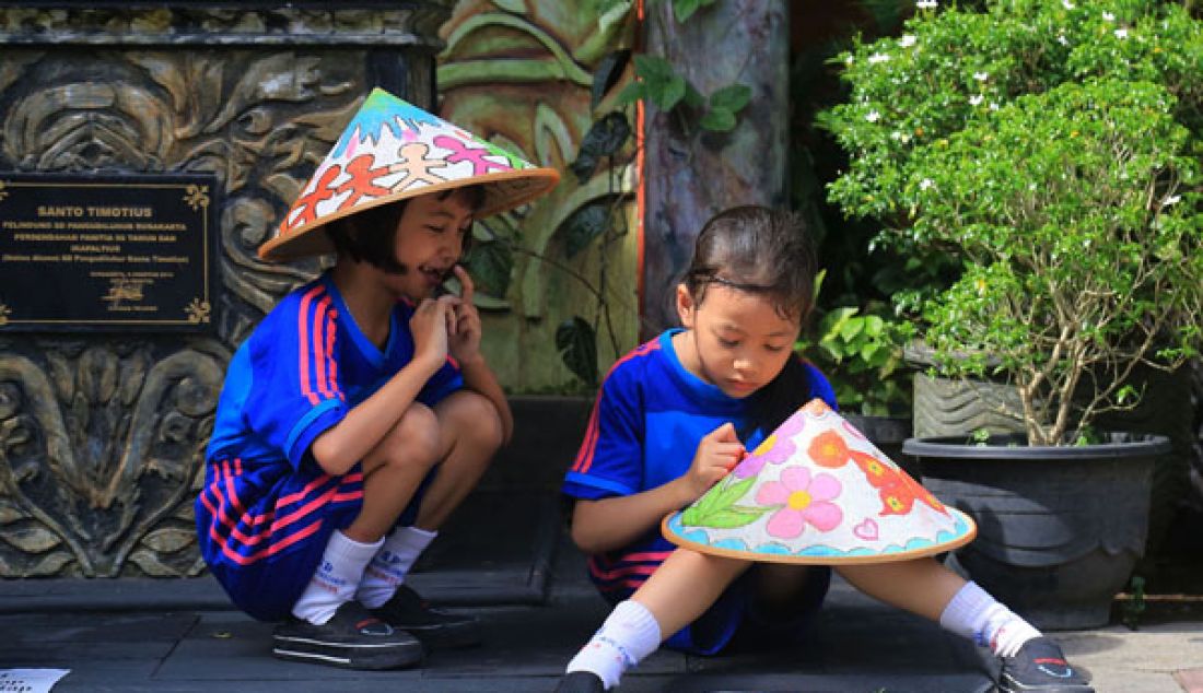 Ratusan siswa kelas I dan kelas II SD Pangudi Luhur St Timiotius menggambar diatas caping (topi tradisional Jawa), Senin (13/3). Kegiatan ini merupakan mid non test yang masuk dalam kurikulum Seni Budaya dan Ketrampilan (SBK), yakni menggambar dalam dua dimensi. - JPNN.com