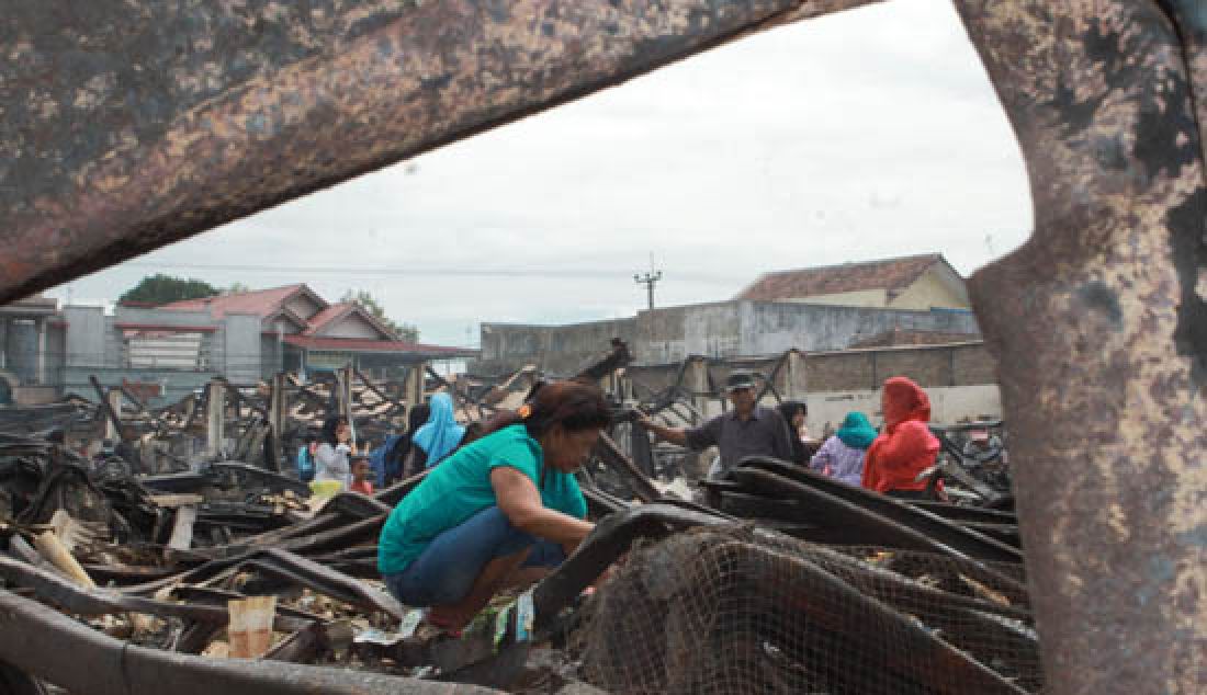 MEMUNGUT: Para pedagang memunguti sisa barang-barang yang terbakar di Pasar Manonjaya Kabupaten Tasikmalaya pada Selasa (14/3) lalu. - JPNN.com