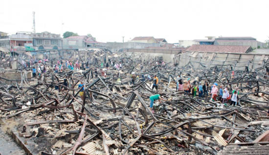 MEMUNGUT: Para pedagang memunguti sisa barang-barang yang terbakar di Pasar Manonjaya Kabupaten Tasikmalaya pada Selasa (14/3) lalu. - JPNN.com