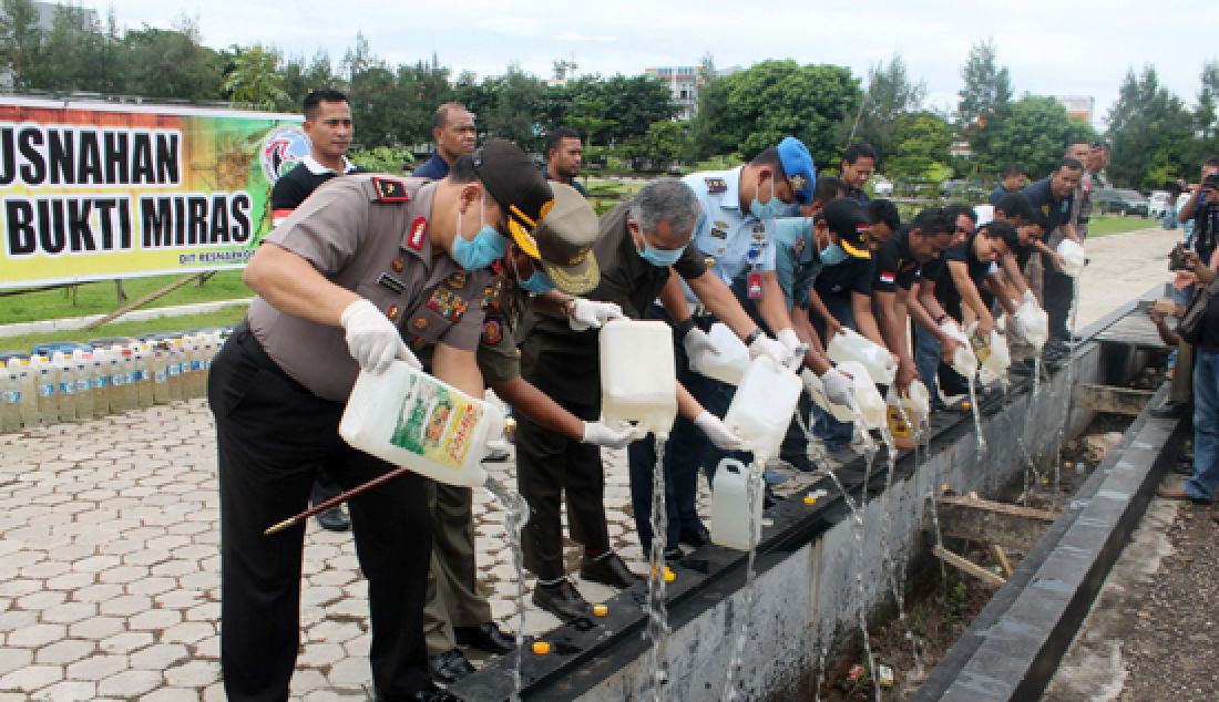 DIMUSNAHKAN: Kapolda NTT, Brigjen Pol Agung Sabar Santoso bersama Forkopimda secara simbolis memusnahkan miras lokal (sopi) di Mapolda NTT, Rabu (15/3). Sebanyak 14 ton miras dimusnahkan. - JPNN.com