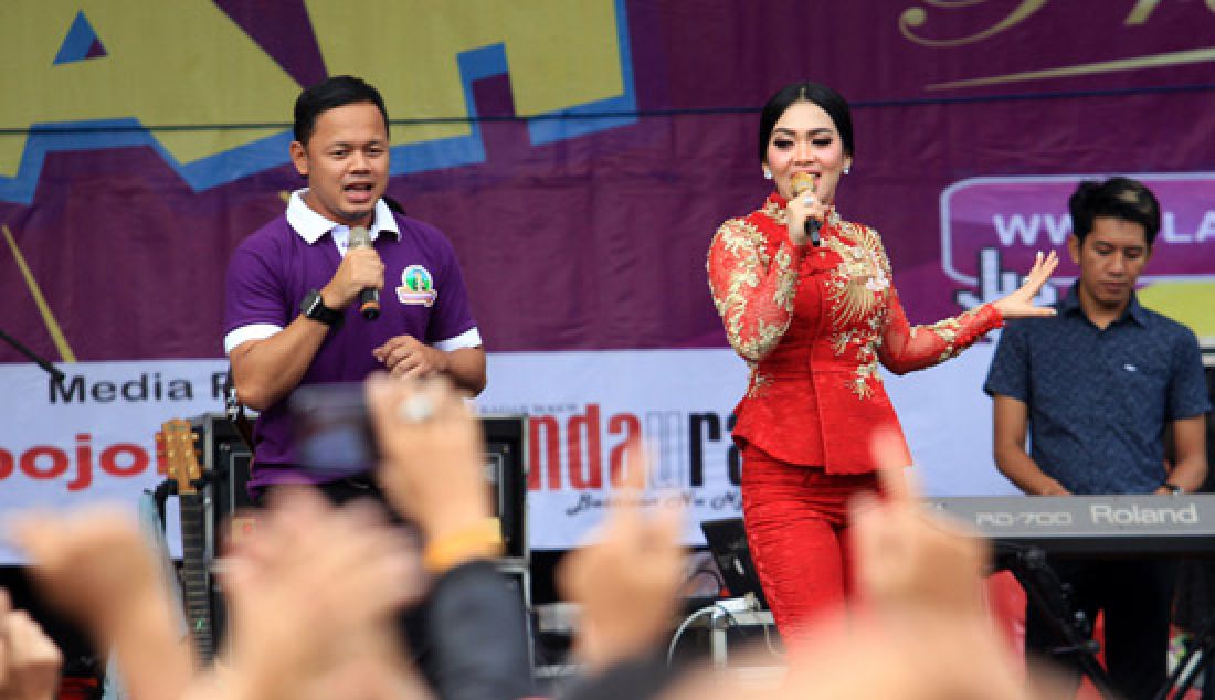 Walikota Bogor, Bima Arya saat berduet bersama artis Syahrini di acara Gebyar Sangkurang Hujan Hadiah di halaman kampus IPB Baranangsiang, Bogor, Minggu (19/3). Acara tersebut dalam rangka penarikan hadiah utama berupa mobil untuk para pelanggan setia. - JPNN.com