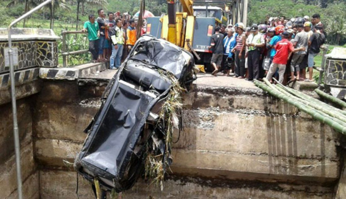 Sebuah mobil jenis Toyota Avanza yang terseret arus sungai Klawing saat oprit jembatan Klawing patah, Minggu (19/3). Kendaran baru berhasil dievaskusi setelah ditarik dengan kendaraan towing. - JPNN.com