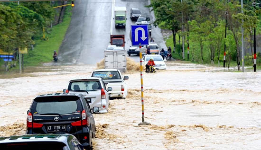 TERGENANG: Hujan lebat yang terjadi di kota Balikpapan, Senin (20/3) membuat beberapa ruas jalan utama tergenang. Ketinggian air mencapai 50 cm hingga 1 meter hingga banyak kendaraan tidak berani melintas. - JPNN.com