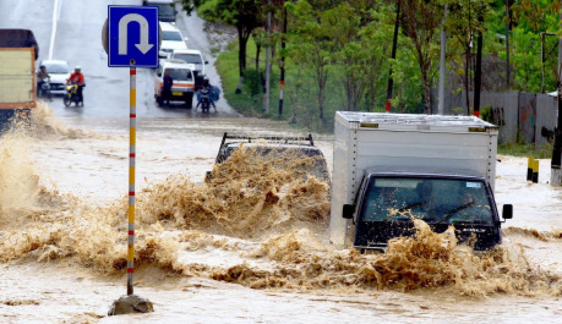 TERGENANG: Hujan lebat yang terjadi di kota Balikpapan, Senin (20/3) membuat beberapa ruas jalan utama tergenang. Ketinggian air mencapai 50 cm hingga 1 meter hingga banyak kendaraan tidak berani melintas. - JPNN.com