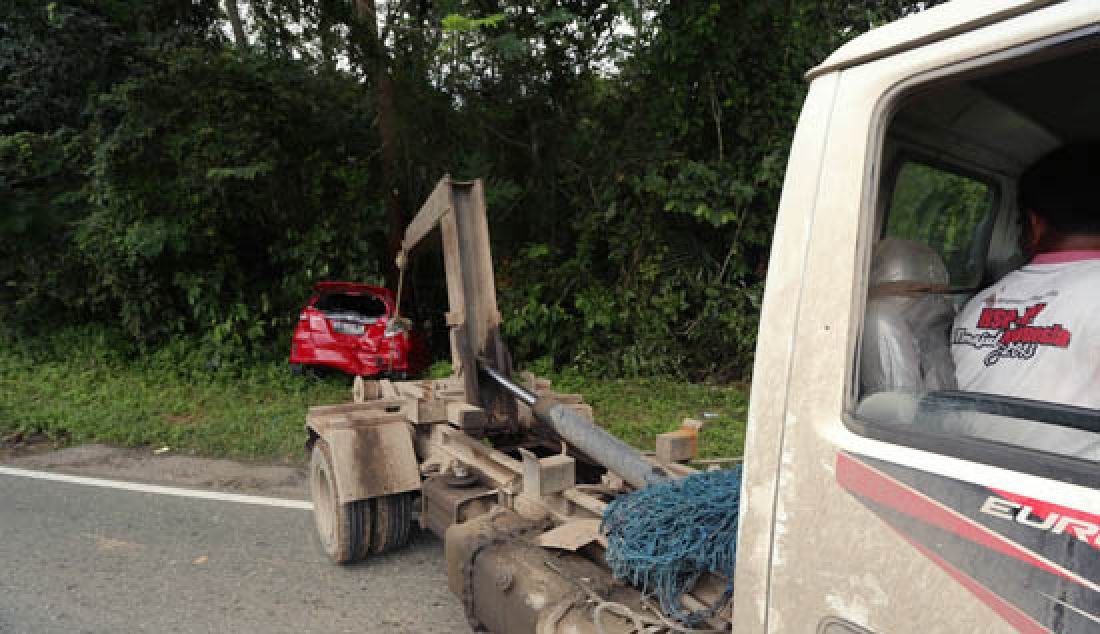 RAWAN: Kecelakaan lalulintas kembali terjadi di Km 11 Jalan Poros Samarinda-Balikpapan, Kamis (23/3) siang. Tak ada korban jiwa dalam insiden yang melibatkan dua kendaraan roda empat tersebut, namun sebuah mobil merah nopol KT 1010 LN rusak cukup parah karena masuk kesemak-semak akibat ditabrak dari belakang. - JPNN.com