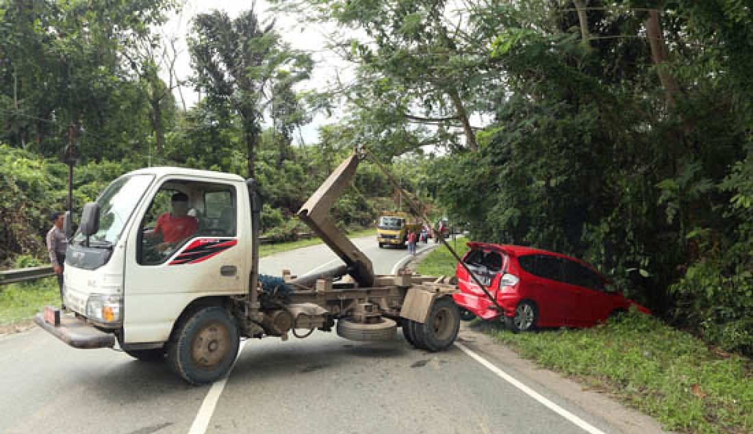 RAWAN: Kecelakaan lalulintas kembali terjadi di Km 11 Jalan Poros Samarinda-Balikpapan, Kamis (23/3) siang. Tak ada korban jiwa dalam insiden yang melibatkan dua kendaraan roda empat tersebut, namun sebuah mobil merah nopol KT 1010 LN rusak cukup parah karena masuk kesemak-semak akibat ditabrak dari belakang. - JPNN.com