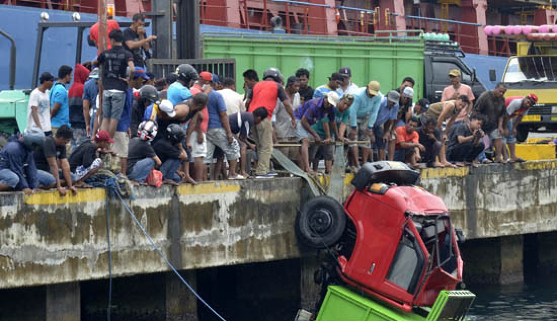 EVAKUASI: Truk yang jatuh ke laut saat dievakuasi buruh pelabuhan dibantu warga di seputaran pelabuhan Ahmad Yani, Kota Baru, Ternate Tengah, Minggu (2/4). - JPNN.com