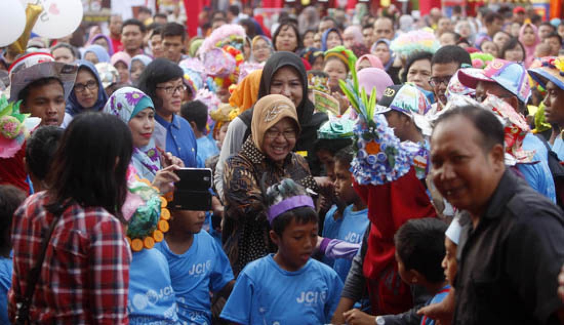 CERIA: Wali Kota Surabaya, Tri Rismaharini saat melakukan jalan sehat bersama 1.200 anak berkebutuhan khusus dalam acara World for Autism di Balai Kota, Minggu (2/4). Salah satu peserta mengikuti jalan sehat dengan menggunakan kursi roda. - JPNN.com