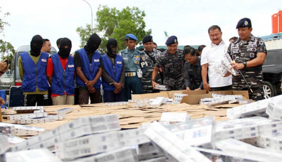 Danlantamal IV Tanjung Pinang Laksamana Pertama (Laksma) TNI S Irawan (kanan) bersama Danlanal Batam Kolonel Laut Ipong Wicaksono dan Ketua DPRD Kepri Jumaga Nadeak menunjukan barang bukti rokok ilegal berserta empat tersangka yang diamankan saat ekpos di Mako Lanal Batam, Rabu (5/4). - JPNN.com