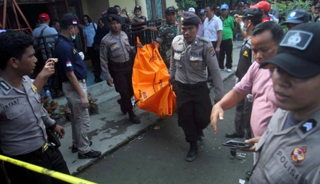 PEMBUNUHAN SATU KELUARGA: Petugas Kepolisian mengangkat salah satu jenazah korban pembunuhan dari dalam rumah di Jalan Kayu Putih Kelurahan Mabar Medan, Minggu (9/4). Polisi masih menyelidiki motif pembunuhan lima orang yang merupakan satu keluarga, dan satu orang balita kritis. - JPNN.com