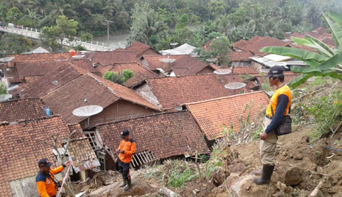 Petugas BPBD Cilacap melakukan assesment terhadap lokasi bencana rawan longsor dari atas jembatan Cikawung menuju Desa Bantarpanjang, Rabu (11/4). - JPNN.com