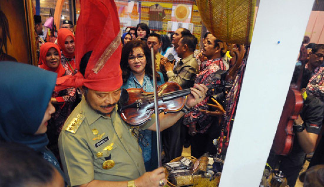 Gubernur Sulsel, Syahrul Yasin Limpo memainkan biola saat meninjau stan dari berbagai Kabupaten dan Kota yang ikut meramaikan kegiatan Temu Kader PKK dan Gebyar Kriya, Karya dan Cinta Budaya Sulsel di Four Points by Sheraton, Makassar, Senin (17/4). - JPNN.com