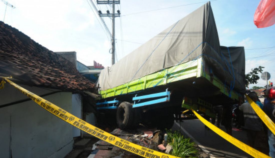 NYUNGSEP: Truk nopol W 8433 UV mengalami kecelakaan tunggal di dekat traffic light Cungking, Jalan Brawijaya Banyuwangi, Kamis (20/4). Gara-gara rem blong truk pengangkut 12 ton beras yang disopiri M. Ali, 30, itu menghajar rumah warga. Sopir truk hanya patah tulang, sedangkan penghuni rumah selamat dari maut. - JPNN.com