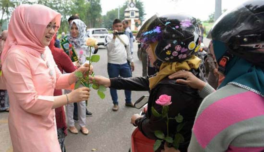 HARI KARTINI: Ketua TPP PKK Kota Jambi memberikan bunga mawar kepada para pengendara perempuan di Hari Kartini. - JPNN.com