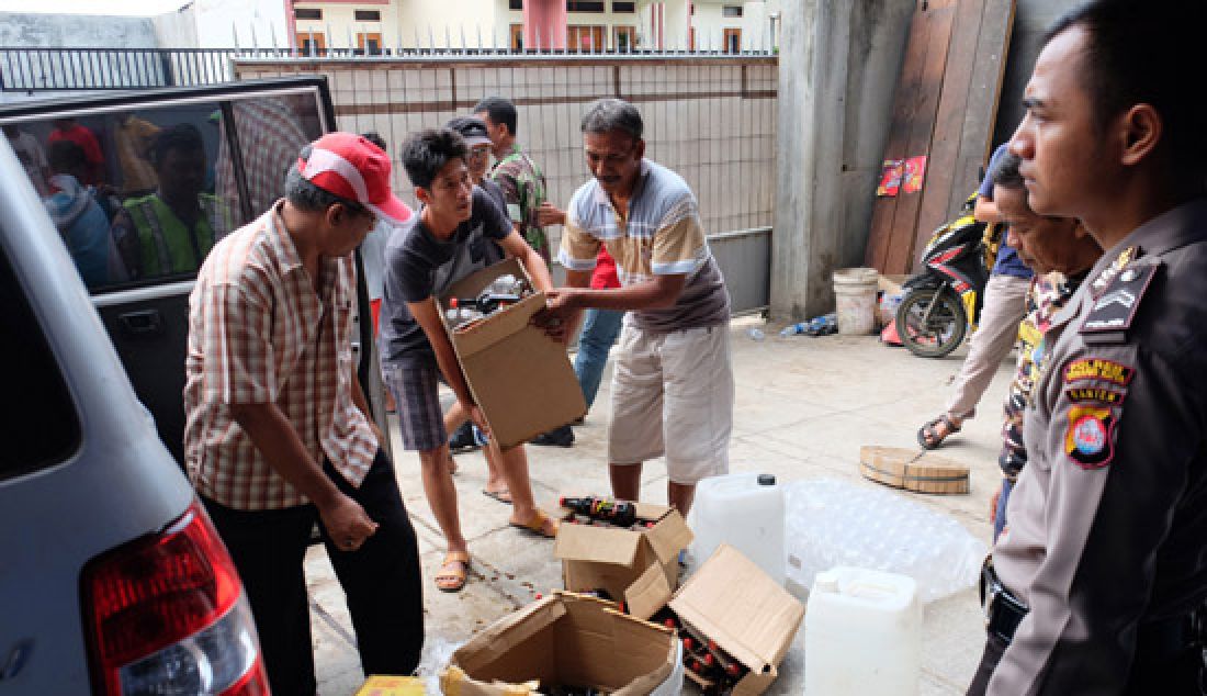 Warga melihat-lihat berbagai merk minuman keras (miras) disebuah gudang penyimpanan serta pengoplosan miras usai digrebek warga bersama polisi di Komplek perumahan Pondok Cilegon Indah (PCI), Serang, Selasa (2/5). Ribuan miras berbagai merk berhasil diamankan beserta enam mobil yang juga berisi miras. - JPNN.com