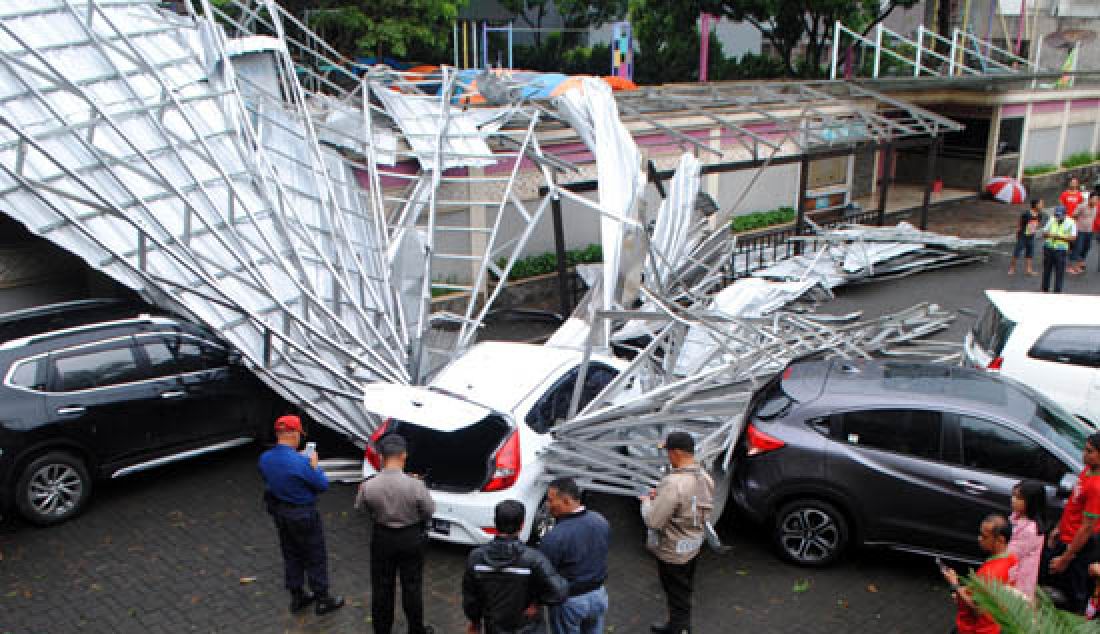 Petugas mengevakuasi atap Sekolah BPK Penabur yang roboh menimpa mobil yang terparkir di di Jalan Candra Kirana, Kota Bandung, Rabu (3/5). Hal tersebut diakibatkan hujan badai. - JPNN.com