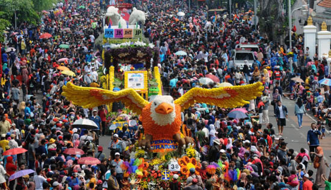 MENYEMUT: Ribuan warga berebut untuk mendekat dengan mobil hias peserta pawai Parade Bunga, saat melintas di Jalan Gubernur Suryo, Surabaya, Minggu (7/5). Pawai peringatan Hari Jadi Kota Surabaya (HJKS) ke-24 tersebut, diikuti sebanyak 70 peserta dari Tugu Pahlawan hingga Taman Bungkul Surabaya. - JPNN.com