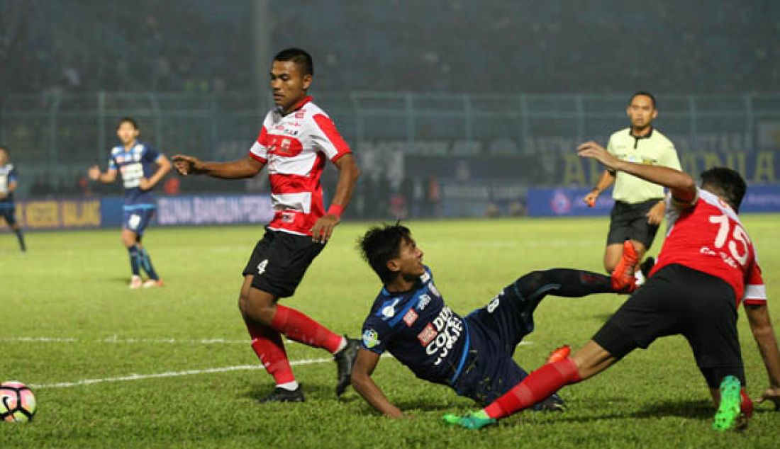 Kapten arema FC Ahmad John Alfarizie gagal melewati hadangan bek madura unites Fabiano (kanan) dan asep berlian kiri di lanjutan liga 1 gojektraveloka yang berakhir 1 - 1 di stadion Kanjuruhan Malang. - JPNN.com