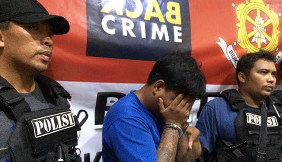 MALU: Amir Rojali, pelaku penusukan terhadap ibu dan anak berusaha menutupi wajahnya saat diekspose pada jumpa pers di Polres Tangerang Selatan, Kamis (25/5). - JPNN.com