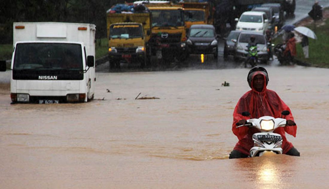 Sebuah mobil boks dan pengemudi sepeda motor terjebak banjir di jalan Sudirman depan Perumahan Simpang Raya Batamcenter, Jumat (26/5). Hujan yang menguyur Batam mengkibatkan sebagian besar daerah di Batamr. - JPNN.com