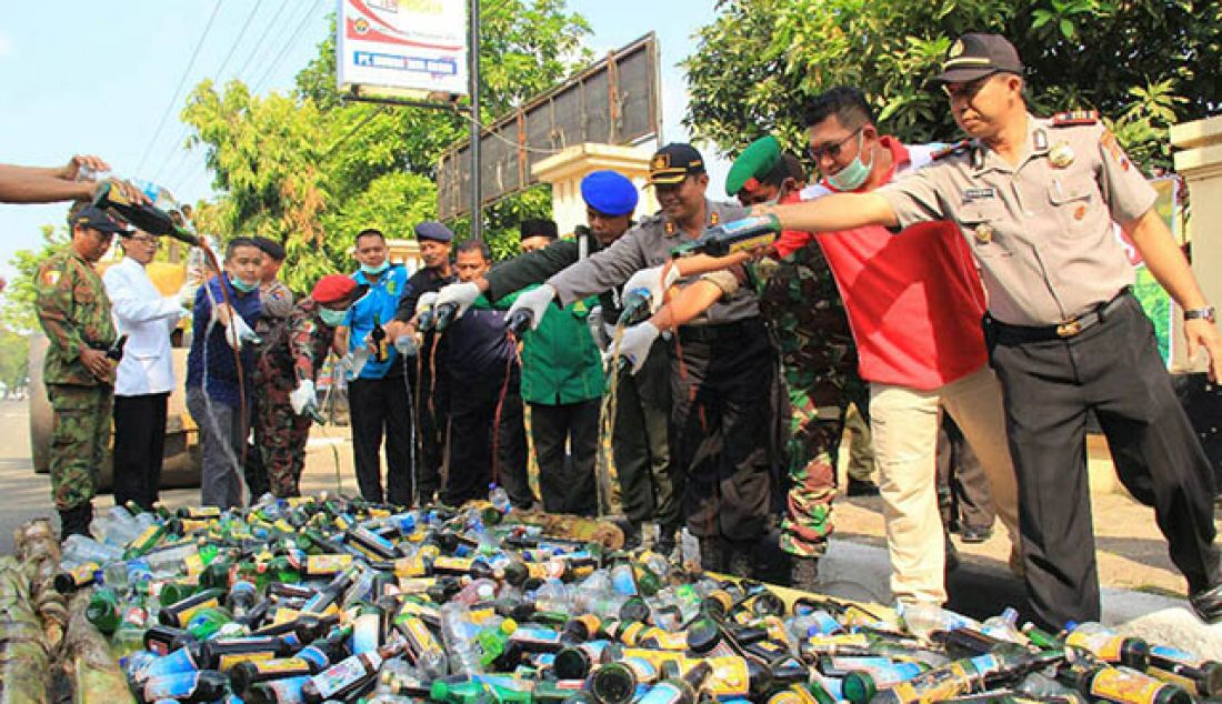 DIMUSNAHKAN: Ribuan botol miras berbagai jenis, dan merek dimusnahkan di depan halaman Mapolres Pekalongan Kota, Jumat (26/5) pagi. - JPNN.com