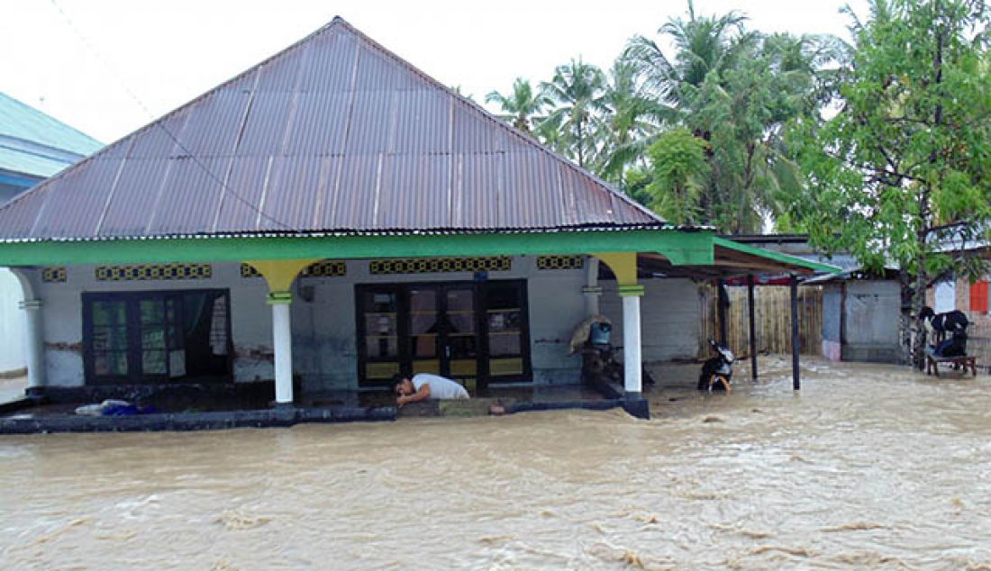 Warga berusaha menyelamatkan perabotan rumah saat banjir bandang melanda wilayah Limboto dan Limboto Barat, Kabupaten Gorontalo, Ahad (18/5). - JPNN.com