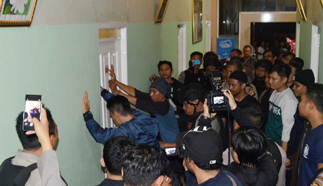 KERJA KERAS: Polisi disaksikan sejumlah awak media berusaha mendobrak pintu kamar 103 di Hotel 95, Kamis (26/5) malam. Pintu kamar jebol, tapi tidak ada penghuninya. - JPNN.com