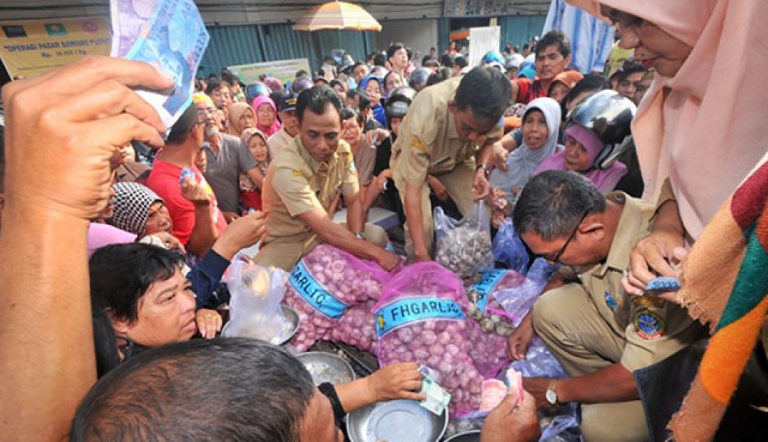 Warga berdesak-desakan menyerbu operasi pasar bawang putih di halaman Pasar Flamboyan Pontianak, Selasa(30/5). Harga per kilo bawang putih dalam operasi pasar ini Rp 30 ribu guna menstabilkan harga komoditas tersebut yang melambung tinggi di pasaran. - JPNN.com