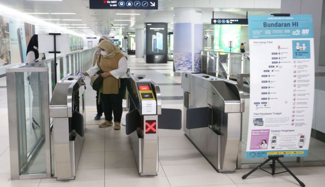 Calon penumpang memindai kode batang (QR Code) untuk keluar dari gerbang di Stasiun MRT Bundaran HI, Jakarta, Selasa (31/8). - JPNN.com