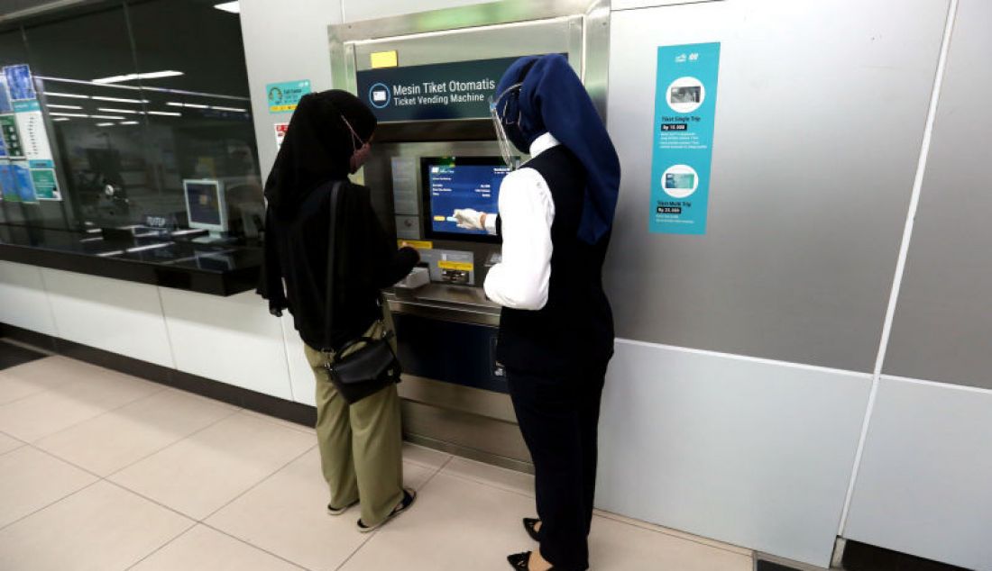 Petugas saat membantu calon penumpang membeli tiket di mesin tiket otomatis di Stasiun MRT Bundaran HI, Jakarta, Selasa (31/8). - JPNN.com