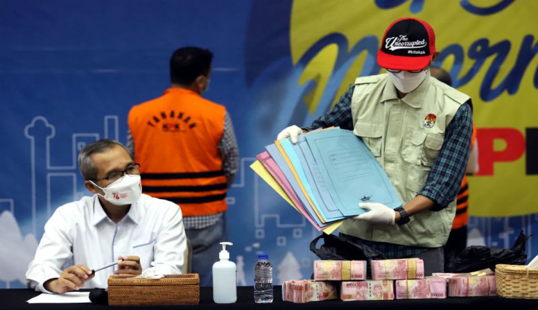 Wakil Ketua KPK Alexander Marwata (duduk kiri) menyaksikan penyidik KPK menunjukkan barang bukti hasil operasi tangkap tangan (OTT) Bupati Purbolinggo di gedung KPK, Jakarta, Selasa (31/8). - JPNN.com