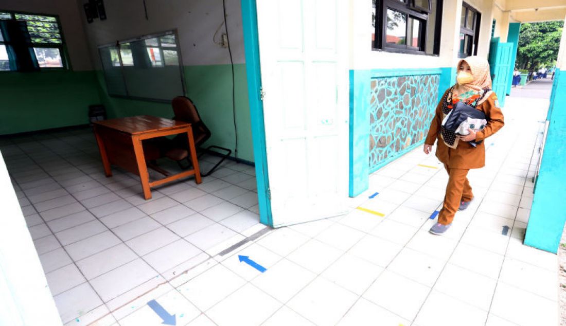Seorang guru saat memasuki kelas di SMP N 11, Tangerang Selatan, Banten, Senin (6/9).Pemerintah Kota Tangerang Selatan mengizinkan 168 SMP untuk memulai pembelajaran tatap muka (PTM) secara terbatas. - JPNN.com