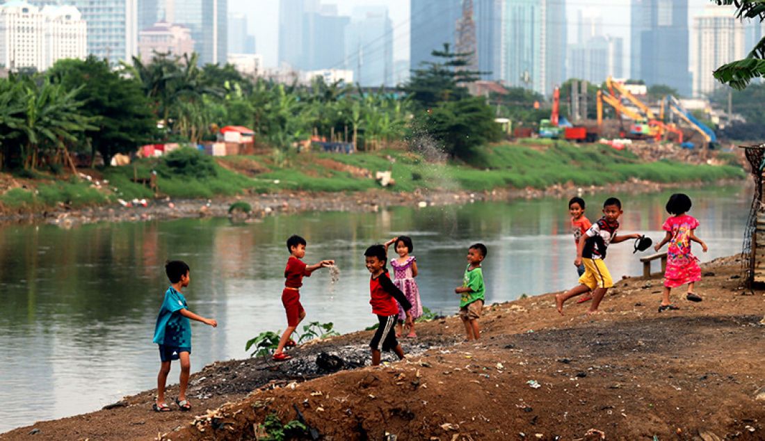 Sejumlah anak-anak bermain sepakbola di bantaran sungai Ciliwung Kanal Banjir Barat, Jakarta, Minggu (29/8). Kurangnya fasilitas sosial seperti tempat olahraga atau taman bermain menyebabkan anak-anak bermain di lokasi yang relatif berbahaya. - JPNN.com