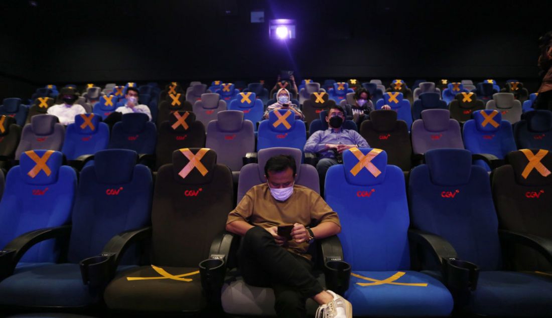 Pengunjung duduk di kursi penonton bioskop CGV, Grand Indonesia, Jakarta, Kamis (16/9). Sejumlah bioskop di Jakarta mulai beroperasi kembali di masa PPKM level 3 dengan penerapan protokol kesehatan yang ketat. - JPNN.com