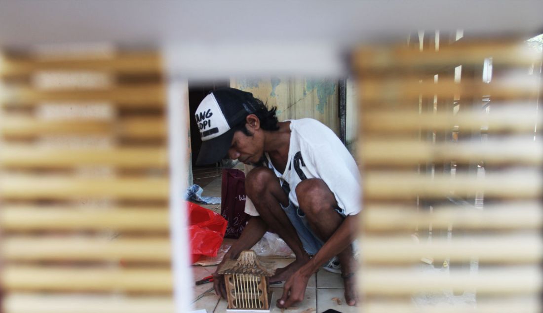 Perajin saat membuat kerajinan lampu hias berbentuk rumah adat di Mienani Craft, Depok, Jawa Barat, Jumat (17/9). - JPNN.com