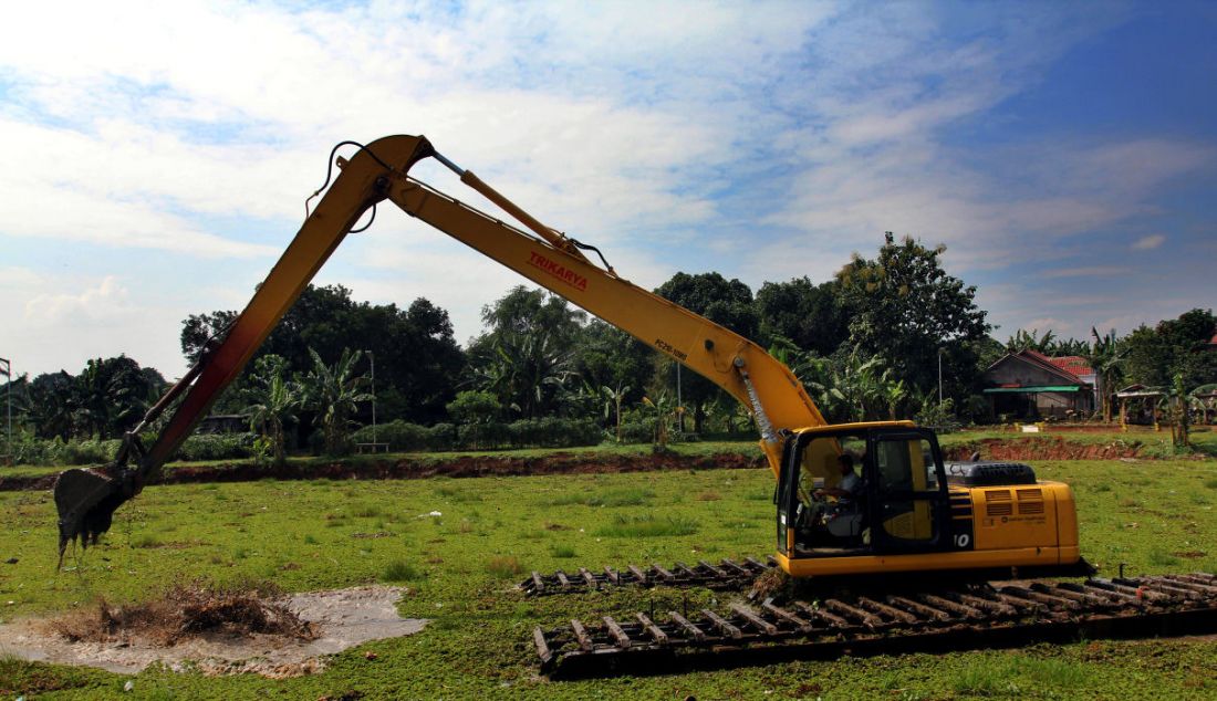 Pekerja menggunakan alat berat membersihkan tanaman gulma di Situ Tujuh Muara, Depok, Jawa Barat, Senin (20/9). - JPNN.com
