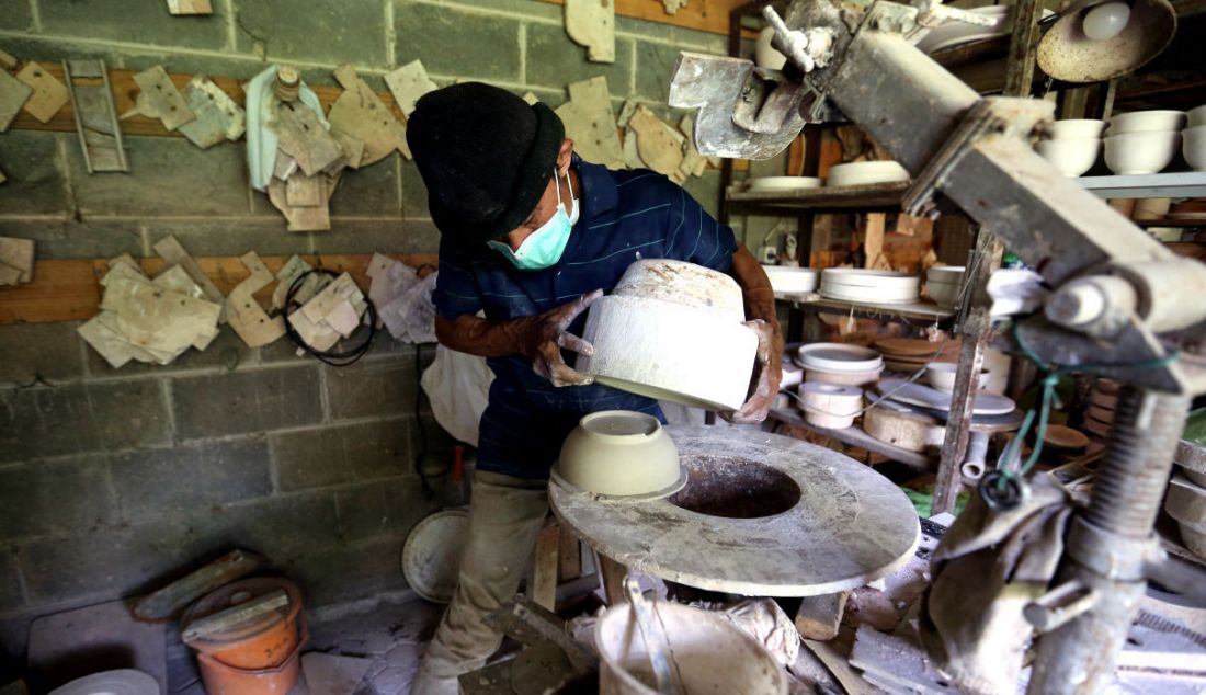 Perajin saat mengeluarkan keramik dari cetakan usai dibuat secara handmade di Pekunden Pottery, Bojongsari, Depok, Jawa Barat, Kamis (23/9). - JPNN.com