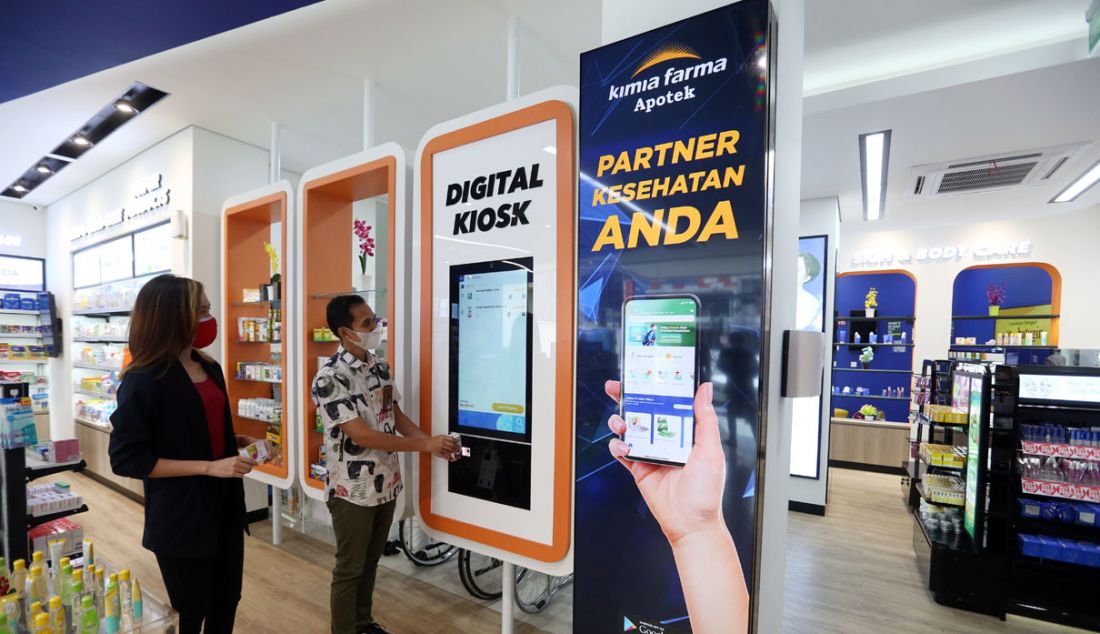 Pharmacy Manager KF Premier Radio Dalam Jakarta Selatan Asep Rahmat Gofur (kanan) menunjukkan cara pembayaran produk secara digital kepada pengunjung di outlet Apotek Kimia Farma Premier Radio Dalam, Jakarta, Sabtu (9/10). - JPNN.com
