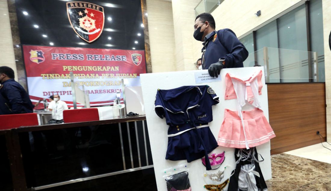 Petugas membawakan barang bukti saat rilis kasus judi online dan prostitusi di Bareskrim Polri, Jakarta, Selasa (26/10). - JPNN.com