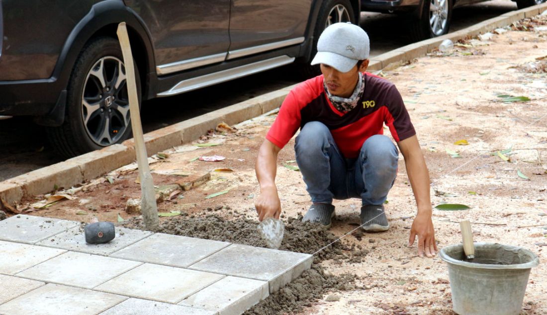 Pekerja menyelesaikan proyek revitalisasi trotoar di Jalan Suryo, Jakarta Selatan, Selasa (2/11). Penataan trotoar dilakukan dengan konsep penataan complete street, yaitu penataan ulang ruas jalan sesuai dengan fungsinya untuk mengakomodir seluruh kebutuhan pengguna jalan sesuai porsi yang tepat dengan memprioritaskan pejalan kaki, pesepeda, dan pengguna transportasi umum. - JPNN.com